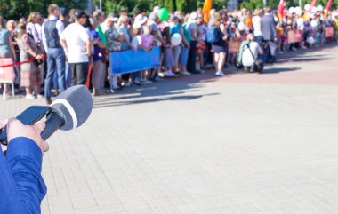 Arkaplanda mikrofon olan bir muhabirin elleri. Röportaj ve haber kavramı, metin için alanı kopyala