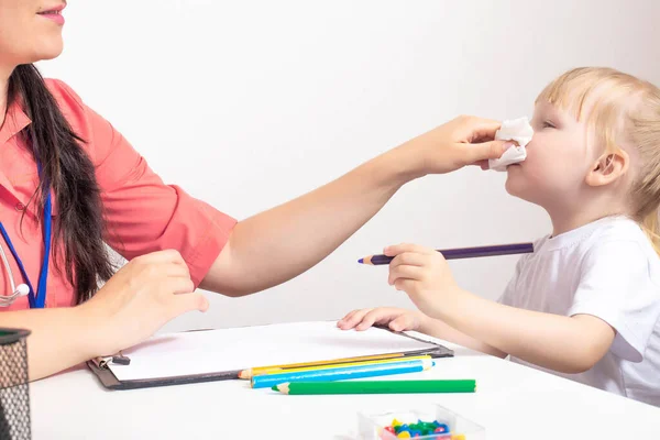 Dokter kinderarts veegt de neus van snot naar een kind een klein meisje van 3 jaar oud. Het concept van de behandeling van een loopneus bij kinderen en neusverstopping. Bacteriële infectie, kopieerruimte — Stockfoto