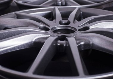 Siyah arka planda alüminyumdan yapılmış modern otomotiv alaşımı tekerleği, endüstri. Araba ve tamirci için tasarımcı moda tekerlekleri