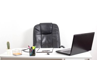 Klinikteki modern doktorun ofisi. Siyah ofis koltuğu ve dizüstü bilgisayar, kırtasiye ve stetoskop, kopyalama alanı