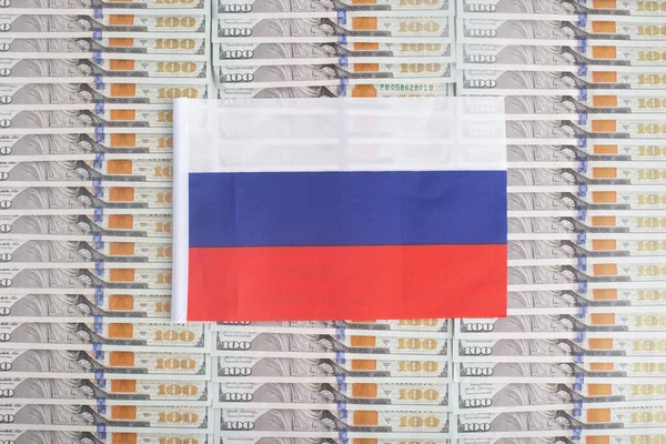 Russia flag on a background from dollar banknotes. Concept of the relationship of the Russian money in relation to the dollar, the country\'s economy, industry