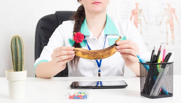 Der Urologe hält eine verdorbene Banane in der Hand. Das Konzept der männlichen Krankheiten, Wechseljahre des Mannes, Ejakulationsstörungen — Stockfoto