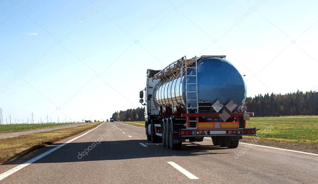 Tanker truck transporting bulk cargo on the highway, industry. Concept for the transportation of oil products and liquid food cargo, copy space for text