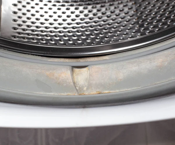 Грязь и грибок от влаги на герметичной жвачке барабана стиральной машины. Концепция чистоты и ухода стиральной машины — стоковое фото