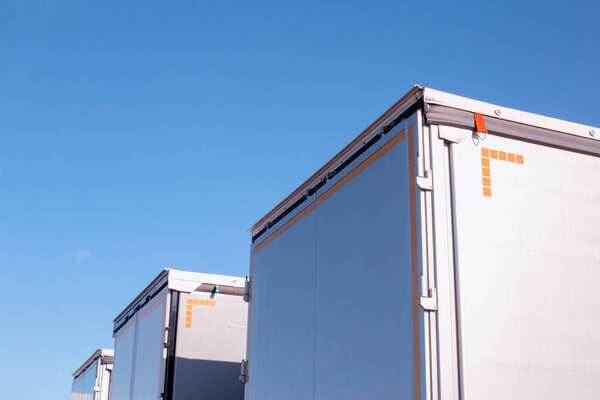 Грузовые полуприцепы Изотерма на фоне голубого неба. Концепция мощности и объема современного полуприцепа в грузовых перевозках, промышленности. Копирование текста