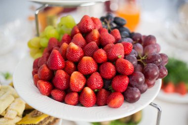 Çilek ve üzüm bir plaka üzerinde