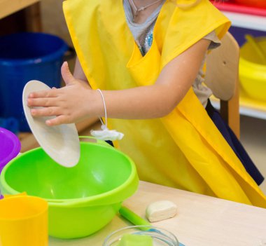 Kız mutfakta bulaşıkları yıkar