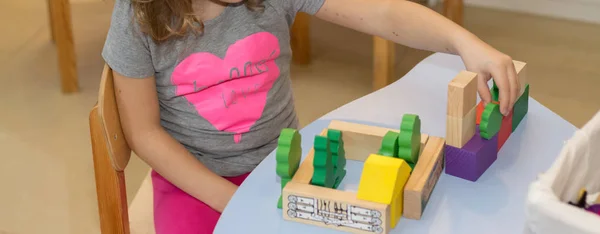 Girl playing in wooden constructor