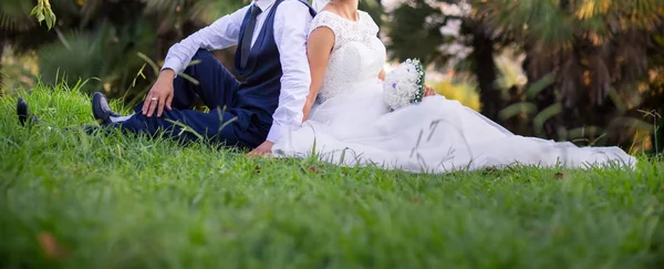 芝生の上に座っている新婚夫婦 — ストック写真