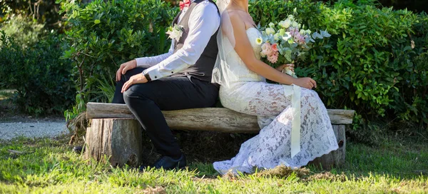公園の丸太の上に座っている新婚夫婦 — ストック写真