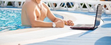 Adam bir dizüstü bilgisayar ile su havuzunda