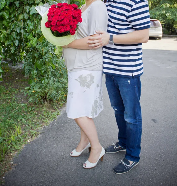 Married couple holds flowers hugging