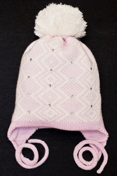Hand-knitted baby hat on a uniform background