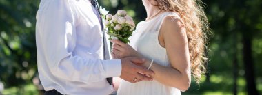 Yeni evliler buketi bir arada tutarlar.