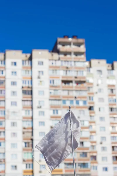 旗竿に医療マスク 高層ビルを背景に白旗 医療用マスクから作られた白い旗 — ストック写真