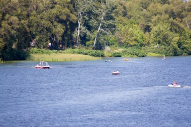 Tatilciler nehirde tekne ve tekneye biniyor. Dinyeper Nehri, Kiev