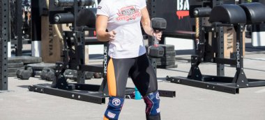 Sporcu yarışmada bir dambılı kaldırıyor