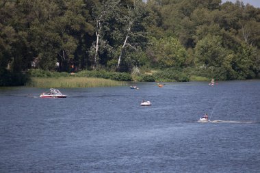 Tatilciler nehirde tekne ve tekneye biniyor. Dinyeper Nehri, Kiev
