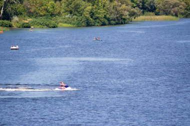 Tatilciler nehirde tekne ve tekneye biniyor. Dinyeper Nehri, Kiev