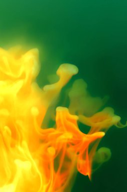 Yeşil arka plan üzerinde soyut ateşli şekilleri