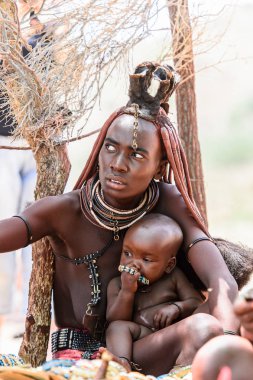 Kamanjab, Namibya - 07 Eylül 2015: Himba kabilesinden bir bebeği olan kimliği belirsiz kadın. Himba kuzey Namibya ve Angola yaşayan yerli halk