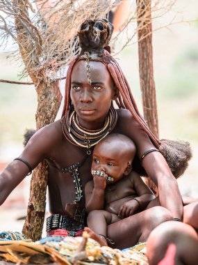 Kamanjab, Namibya - 07 Eylül 2015: Himba kabilesinden bir bebeği olan kimliği belirsiz kadın. Himba kuzey Namibya ve Angola yaşayan yerli halk