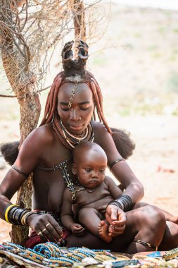 Kamanjab, Namibya - 07 Eylül 2015: Himba kabilesinden bir bebeği olan kimliği belirsiz kadın. Himba kuzey Namibya ve Angola yaşayan yerli halk