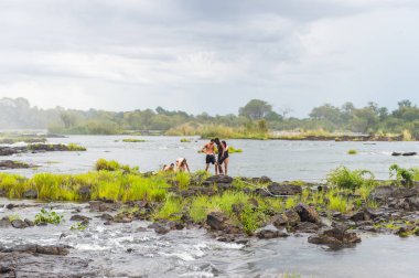 Livingstone Adası, Zambiya - 14 Ocak 2016: Kimliği belirsiz turistler, İskoç kaşif David Livingstone'un adını taşıyan Livingstone Adası'ndaki Zambezi nehrinde yüzmek üzere,