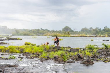 Livingstone Adası, Zambiya - 14 Ocak 2016: Kimliği belirsiz turistler, İskoç kaşif David Livingstone'un adını taşıyan Livingstone Adası'ndaki Zambezi nehrinde yüzmek üzere,