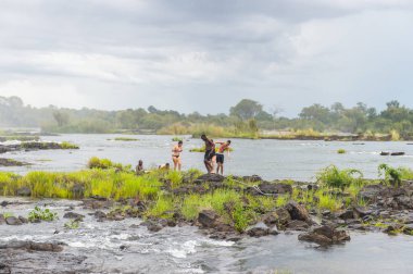 Livingstone Adası, Zambiya - 14 Ocak 2016: Kimliği belirsiz turistler, İskoç kaşif David Livingstone'un adını taşıyan Livingstone Adası'ndaki Zambezi nehrinde yüzmek üzere,