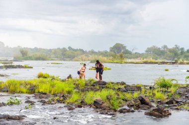 Livingstone Adası, Zambiya - 14 Ocak 2016: Kimliği belirsiz turistler, İskoç kaşif David Livingstone'un adını taşıyan Livingstone Adası'ndaki Zambezi nehrinde yüzmek üzere,