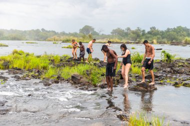 Livingstone Adası, Zambiya - 14 Ocak 2016: Kimliği belirsiz turistler, İskoç kaşif David Livingstone'un adını taşıyan Livingstone Adası'ndaki Zambezi nehrinde yüzmek üzere,