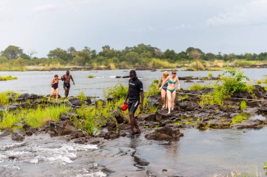 Livingstone Adası, Zambiya - 14 Ocak 2016: Kimliği belirsiz turistler, İskoç kaşif David Livingstone'un adını taşıyan Livingstone Adası'ndaki Zambezi nehrinde yüzecek,
