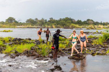 Livingstone Adası, Zambiya - 14 Ocak 2016: Kimliği belirsiz turistler, İskoç kaşif David Livingstone'un adını taşıyan Livingstone Adası'ndaki Zambezi nehrinde yüzecek,