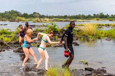 Livingstone Adası, Zambiya - 14 Ocak 2016: Kimliği belirsiz turistler, İskoç kaşif David Livingstone'un adını taşıyan Livingstone Adası'ndaki Zambezi nehrinde yüzecek,