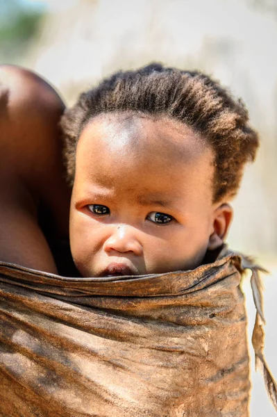 纳米比亚温得和克以东 2016年1月3日 不明身份的丛林人婴儿在母亲背上 布什曼人是南部非洲土著狩猎采集者的成员 — 图库照片