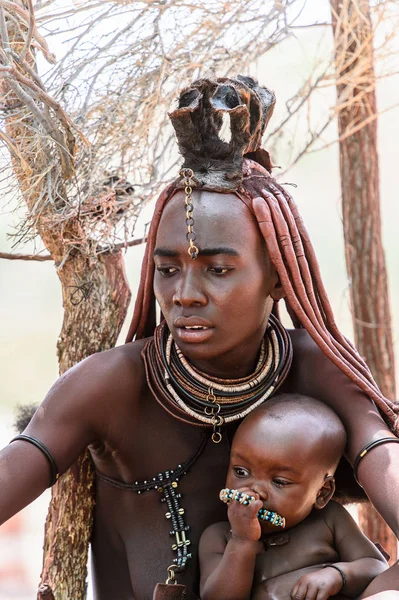 Kamanjab, Namibya - 07 Eylül 2015: Himba kabilesinden bir bebeği olan kimliği belirsiz kadın. Himba kuzey Namibya ve Angola yaşayan yerli halk