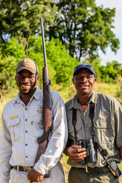 stock image OKAVANGO DELTA, BOTSWANA - JAN 11, 2016: Unidentified Botswana men with gun and smile. They work to protect people from the wild animal at the Moremi Game Reserve