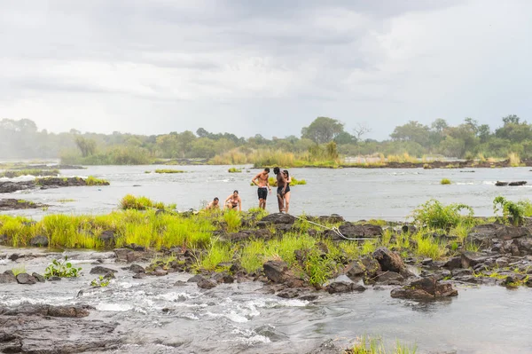 Livingstone Adası, Zambiya - 14 Ocak 2016: Kimliği belirsiz turistler, İskoç kaşif David Livingstone'un adını taşıyan Livingstone Adası'ndaki Zambezi nehrinde yüzmek üzere,