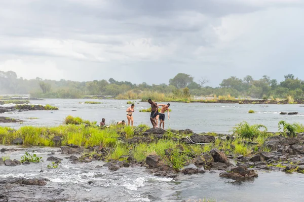 Livingstone Adası, Zambiya - 14 Ocak 2016: Kimliği belirsiz turistler, İskoç kaşif David Livingstone'un adını taşıyan Livingstone Adası'ndaki Zambezi nehrinde yüzmek üzere,