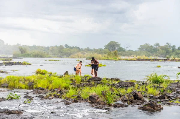 Livingstone Adası, Zambiya - 14 Ocak 2016: Kimliği belirsiz turistler, İskoç kaşif David Livingstone'un adını taşıyan Livingstone Adası'ndaki Zambezi nehrinde yüzmek üzere,