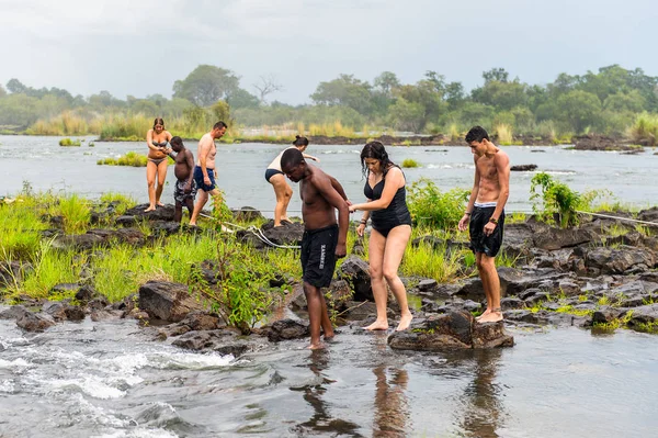 Livingstone Adası, Zambiya - 14 Ocak 2016: Kimliği belirsiz turistler, İskoç kaşif David Livingstone'un adını taşıyan Livingstone Adası'ndaki Zambezi nehrinde yüzmek üzere,