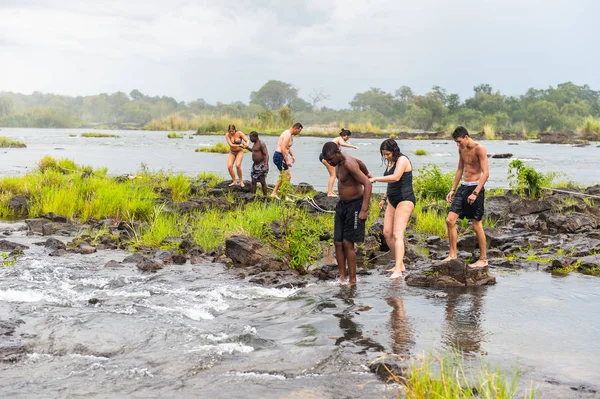 Livingstone Adası, Zambiya - 14 Ocak 2016: Kimliği belirsiz turistler, İskoç kaşif David Livingstone'un adını taşıyan Livingstone Adası'ndaki Zambezi nehrinde yüzmek üzere,