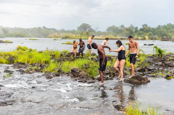 Livingstone Adası, Zambiya - 14 Ocak 2016: Kimliği belirsiz turistler, İskoç kaşif David Livingstone'un adını taşıyan Livingstone Adası'ndaki Zambezi nehrinde yüzmek üzere,