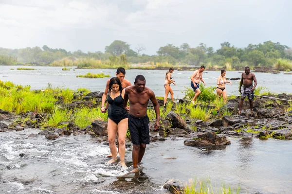 Livingstone Adası, Zambiya - 14 Ocak 2016: Kimliği belirsiz turistler, İskoç kaşif David Livingstone'un adını taşıyan Livingstone Adası'ndaki Zambezi nehrinde yüzmek üzere,