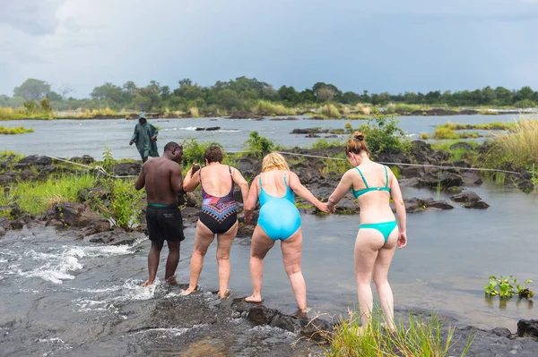 Livingstone Adası, Zambiya - 14 Ocak 2016: Kimliği belirsiz turistler, İskoç kaşif David Livingstone'un adını taşıyan Livingstone Adası'ndaki Zambezi nehrinde yüzecek,