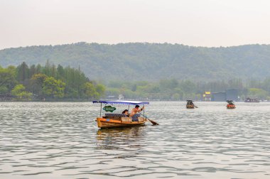 Hangzhou, Çin - 2 Nisan 2016: Batı Gölü'ndeki geleneksel Çin teknesi (Xi hu gölü) Hangzhou'da bir tatlı su gölüdür. Unesco Dünya Mirası Sit