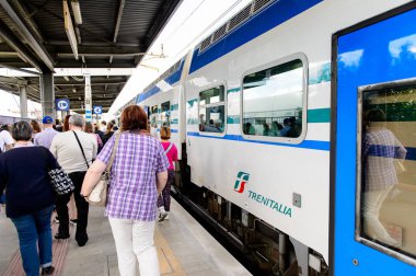 Floransa, İtalya - 6 Mayıs 2016: Trenitalia şirketi Floransa yakınlarındaki bir istasyonda trenle iniyor. Trenitalia İtalya'da birincil tren operatörü