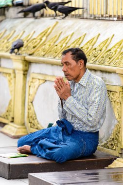 Yangon, Myanmar - 24 Ağustos 2016: Kimliği belirsiz Birmanyalı adam tapınakta dua ediyor. Myanma halkının yüzde 68'i Bamar etnik grubuna mensandı