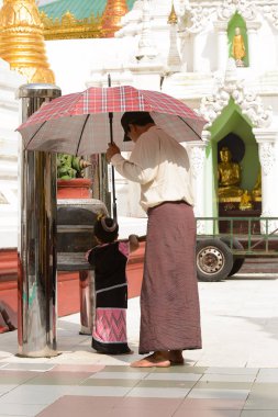 Yangon, Myanmar - 24 Ağustos 2016: Yerel bir tapınakta tanımlanamayan Birmanyalı baba ve kızı. Myanma halkının yüzde 68'i Bamar etnik grubuna mensandı